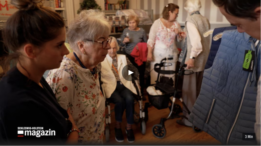 Verkäufer zeigt Seniorin Weste